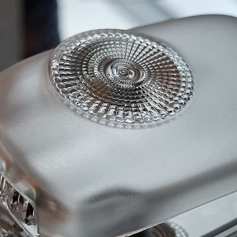 Image of optical lens cap prototype by EXXELENS featuring optically smooth and textured surfaces.